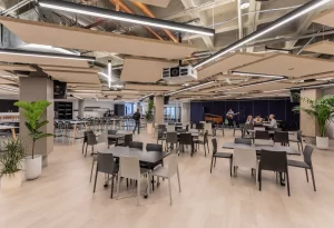 Smart auditorium setup with modular seating, acoustic panels, ceiling-mounted projector, and AV equipment in a modern institutional workspace